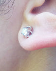 Close-up of an earlobe dressing a natural diamond tulip stud earring.
