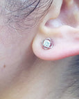 A woman's ear wearing a natural diamond tulip stud earring white gold.