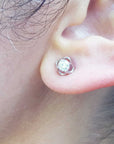 An earlobe wearing a bride's diamond tulip earring in white gold.