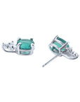 Oval cut natural emerald earrings with diamond accents in 14K white gold.