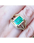Anillo de oro 18k con esmeralda colombiana verde medio de 2.86 ct y tres filas de diamantes.