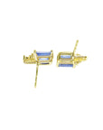 Gold earrings with blue gemstones on a upside down view position.