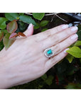 Vintage 2.40 ct Colombian emerald ring in 14K white gold with diamond accents on a hand.