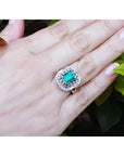 Vintage 2.40 ct Colombian emerald ring in 14K white gold with diamond accents on a hand.