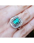Vintage 2.40 ct Colombian emerald ring in 14K white gold with diamond accents on a hand.