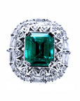 A square emerald-cut surrounded by diamonds, this vintage Colombian emerald ring displays the top side view.