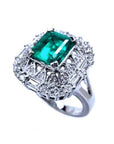 A unique vintage emerald ring with baguette and round diamonds, showing the topside and side profile.