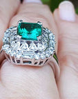 Vintage ring with a colombian emerald and diamond accents on a finger.