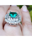 Vintage 2.40 ct Colombian emerald ring in 14K white gold with diamond accents on a finger.