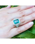 Anillo de oro blanco 18K con esmeralda colombiana rectangular de 3.98 ct. rodeada de diamantes.