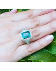 Anillo de oro blanco 18K con esmeralda colombiana rectangular de 3.98 ct. rodeada de diamantes.