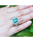 Anillo de oro blanco 18K con esmeralda colombiana rectangular de 3.98 ct. rodeada de diamantes.