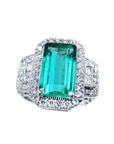 Anillo con una esmeralda cuadrada fina de Muzo colombiana rodeada de diamantes en oro blanco de 18k.
