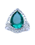 Anillo de compromiso con esmeralda corte pera certificada rodeada de diamantes naturales en oro blanco.