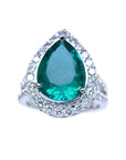 Anillo de compromiso con esmeralda corte pera certificada por GIA rodeada de diamantes naturales en oro blanco.
