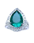 Anillo de compromiso con esmeralda corte pera certificada por GIA rodeada de diamantes naturales en oro blanco.