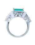 Anillo de oro blanco 18K con esmeralda colombiana rectangular y diamantes, diseño lateral calado.