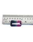 Rectangular emerald cut watermelon tourmaline with vibrant red-orange and deep blue-green colors, next to a ruler.