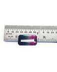 Rectangular emerald cut watermelon tourmaline with vibrant red-orange and deep blue-green colors, next to a ruler.