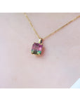 Brazilian bicolor tourmaline watermelon solitaire pendant in 14K yellow gold, worn on a neck.