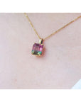 Brazilian bicolor tourmaline watermelon solitaire pendant in 14K yellow gold, worn on a neck.