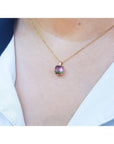 Brazilian bicolor tourmaline watermelon solitaire pendant in 14K yellow gold on a model.