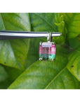 Brazilian bicolor tourmaline watermelon solitaire pendant in 14K yellow gold, held by tweezers.