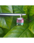 Brazilian bicolor tourmaline watermelon solitaire pendant in 14K yellow gold, held by tweezers.