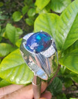 Men's sterling silver ring with a sparkling blue Welo black opal, accented by red and green flashes.