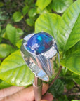 Men's sterling silver ring with a sparkling blue Welo black opal, accented by red and green flashes.