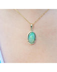 Opal pendant necklace on a person's neck with a blurred background