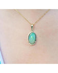 2.86 ct. oval Ethiopian opal pendant with bluish-green hues, prong set in 14K yellow gold on a chain.