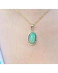 2.86 ct. oval Ethiopian opal pendant with bluish-green hues, prong set in 14K yellow gold on a chain.