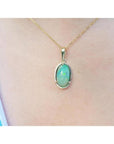 2.86 ct. oval Ethiopian opal pendant with bluish-green hues, prong set in 14K yellow gold on a chain.