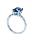 18K white gold ring with a radiant-cut blue sapphire and diamond accents.