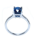 18K white gold ring with a radiant-cut deep blue sapphire and diamond accents.