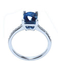 18K white gold ring with a radiant-cut deep blue sapphire and diamond accents.