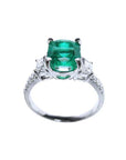 1.90 carat cushion cut emerald and trapezoid diamond ring in 18K white gold.
