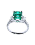 1.90 carat cushion cut emerald and trapezoid diamond ring in 18K white gold.