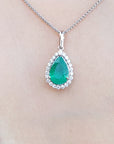 Emerald pendant necklace on a person wearing a black top