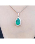 18K white gold pear-shaped emerald pendant with a halo of natural diamonds on a chain.