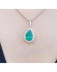 18K white gold pear-shaped emerald pendant with a halo of natural diamonds on a chain.