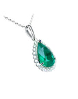 18K white gold pear-shaped emerald pendant with a halo of natural diamonds on a delicate chain.