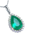 Emerald green teardrop pendant with diamond accents on a right-side position displaying topside view