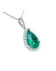 18K white gold pear-shaped emerald pendant with a halo of natural diamonds on a delicate chain.