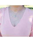 Pear-shaped Welo Ethiopian opal pendant in sterling silver with cubic zirconia, worn on a pink top.