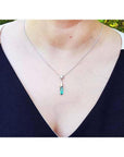 Colombian emerald briolette necklace with a diamond slider on a 14K white gold chain, worn on a person.