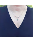 1.28 carat pear cut emerald necklace in 14K white gold with diamond accents and chevron design.