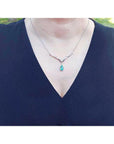 1.28 carat pear cut emerald necklace in 14K white gold with diamond accents and chevron design.