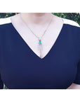 Marquise cut Colombian emerald necklace with diamond links in 14K white gold on a woman's chest.